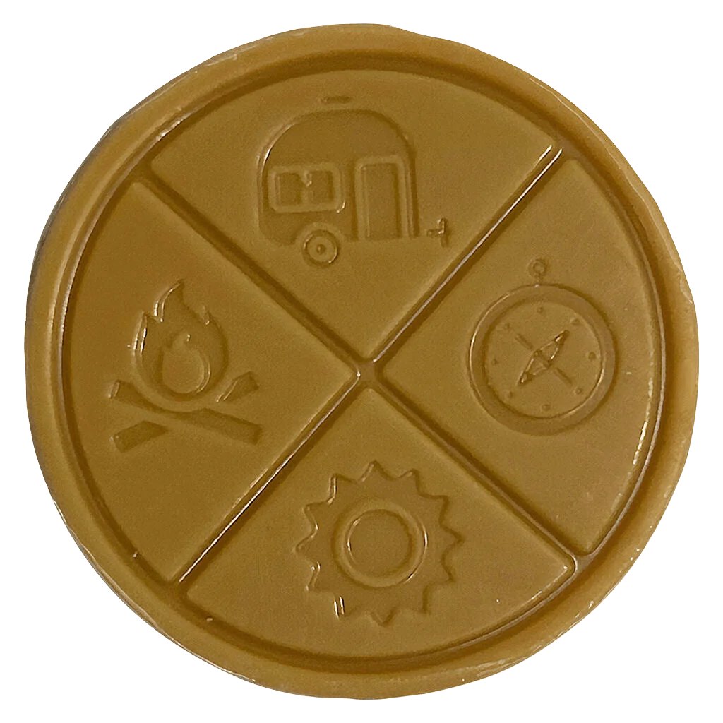 Laughing Ass Caramel Gold Full Spectrum THC chocolate with embossed icons representing adventure, navigation, camping, and fire on tan-colored round disk